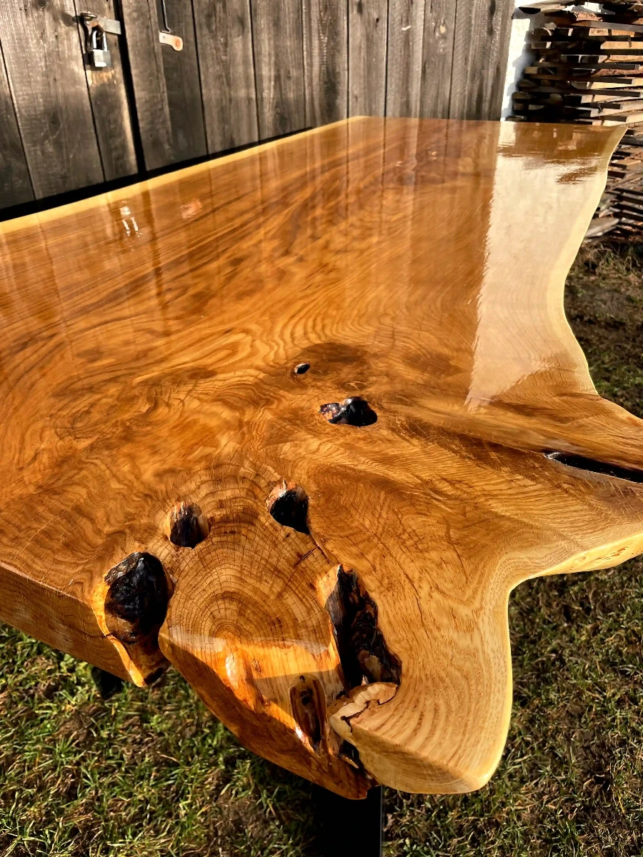 stół jadalniany z monolitu dębowego z naturalną fakturą drewna zabezpieczony lakierem w połysku na metalowych nogach w kształcie X