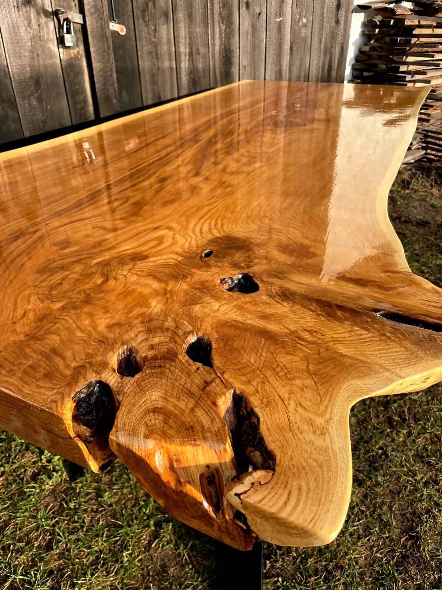 stół jadalniany z monolitu dębowego z naturalną fakturą drewna zabezpieczony lakierem w połysku na metalowych nogach w kształcie X