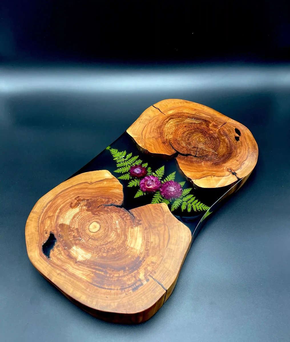 stolik kawowy wykonany z dwóch plastrów jabłoni z zatopioną w żywicy paprocią i suchotnikami