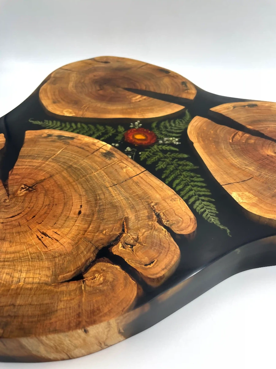 stolik kawowy wykonany z trzech plastrów drewna jabłoni z żywicą i motywem roślinnym