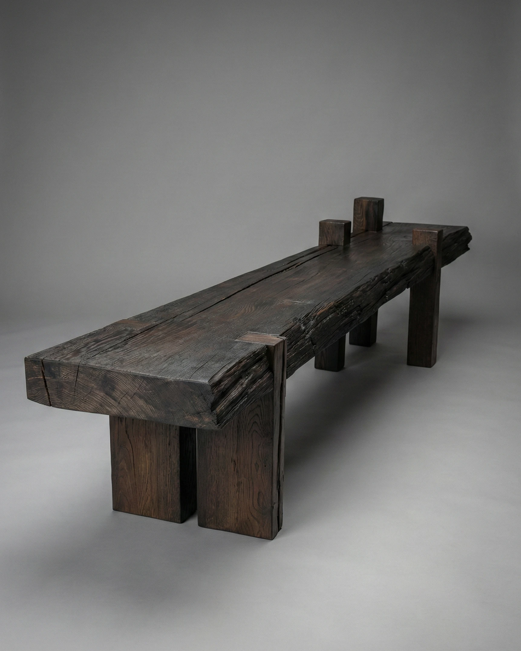 ogromna ława w stylu brutalistycznym wykonana ze szczotkowanego drewna czarnego dębu z naturalnym oflisem